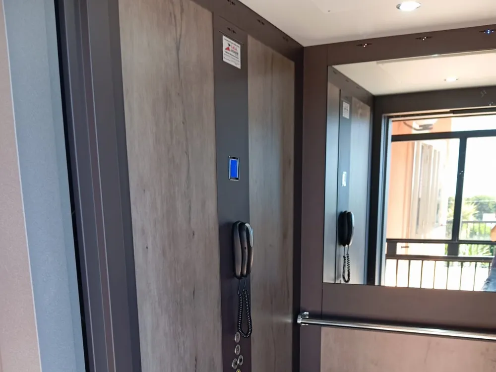 Cabina ascensore moderna con finiture in legno e acciaio